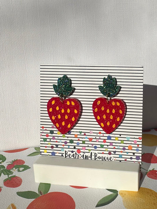 Strawberry earring with leaf topper on a striped branded card
